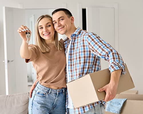 Happy first time homeowners holding new home keys in Florida